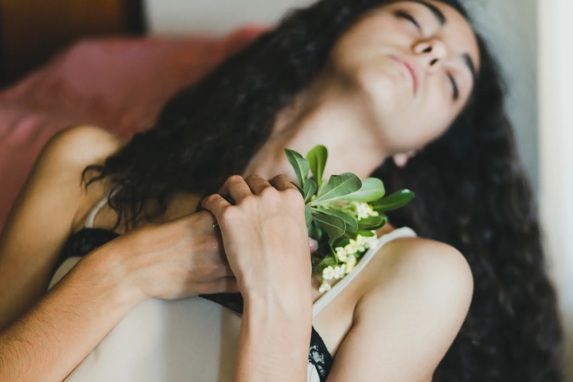 A serene woman holding fresh flowers close to her heart, symbolizing self-care, intimacy, and Gaia in Love’s commitment to empowering women through sexual wellness and self-discovery.