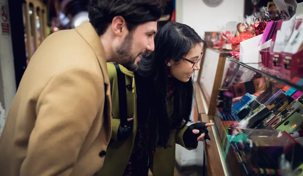 A couple browsing a variety of adult products in a store, reflecting Gaia in Love’s inclusive approach to sex toys for women.