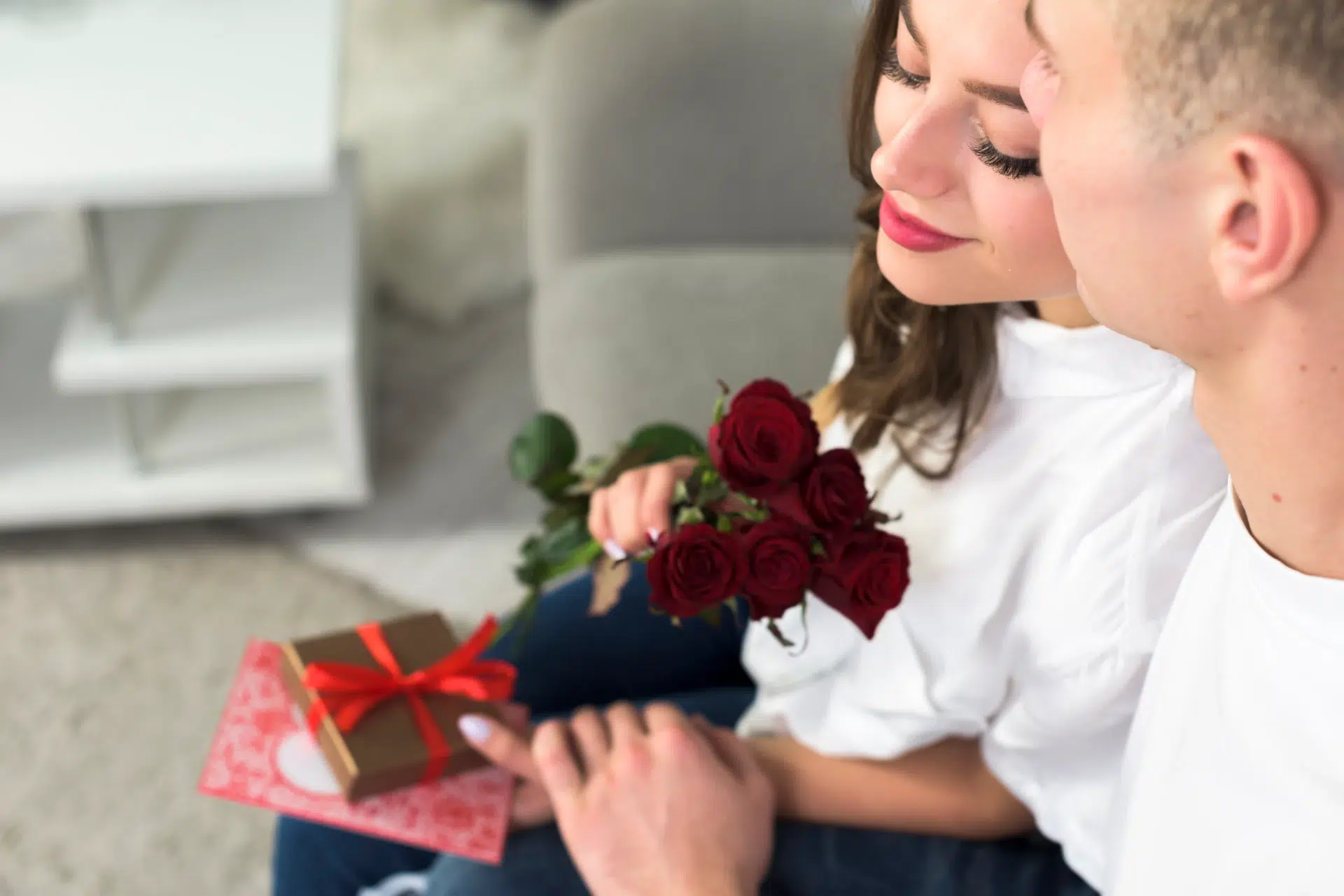 Couple celebrating Valentine’s Day with a gift, red roses, and a card. A thoughtful Valentine’s Day Gift from Gaia in Love.