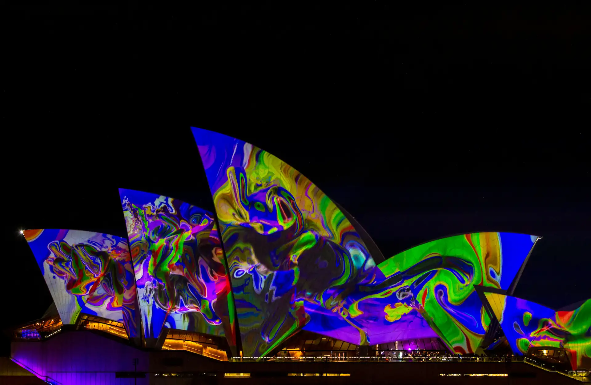 Sydney Opera House illuminated with vibrant lights, symbolizing Australia couples sex toys market and innovations by Gaia in Love.