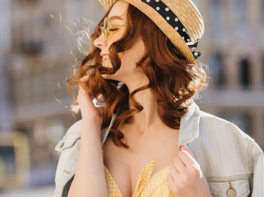 A cheerful woman with red hair in a stylish hat enjoying the outdoors. Perfect representation of confidence and empowerment, aligned with Gaia in Love's mission to support sellers to sell sex toys on Amazon Japan, .