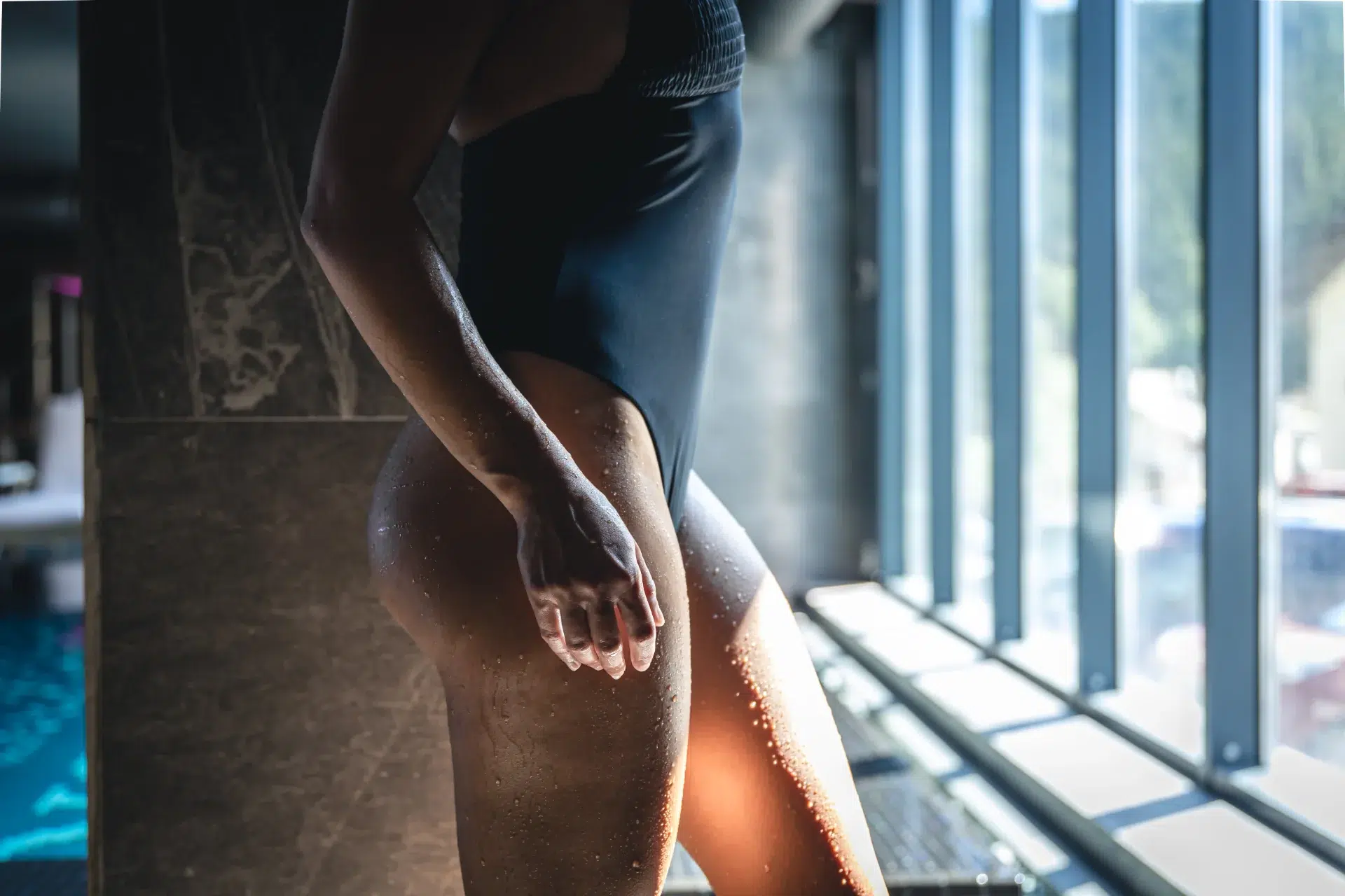 A young woman in a black swimsuit enjoys a moment of relaxation by the pool, embracing self-care and wellness. This peaceful scene represents the confidence and empowerment that Gaia in Love promotes, ideal for those who practice Kegel training for enhanced well-being and personal growth with our Kegel Training Vibrator.