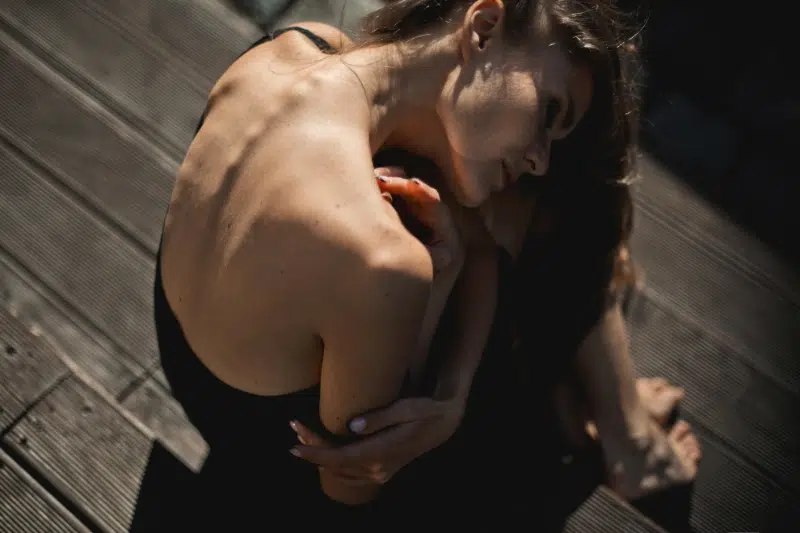 A model in a black dress, showcasing a moment of sensuality and self-reflection, mirroring the empowering effect of Gaia in Love’s adult sex toys.