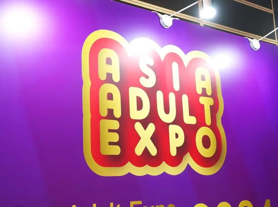 Asia Adult Expo official signage with vibrant purple and gold branding, highlighting the premier B2B adult industry trade show. Gaia in Love participates in the event.
