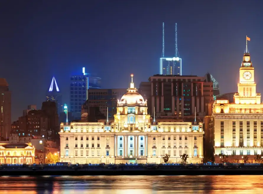Night view of the Shanghai skyline and historic buildings along the Bund, representing the global stage of API SHANGHAI 2025 with Gaia in Love.