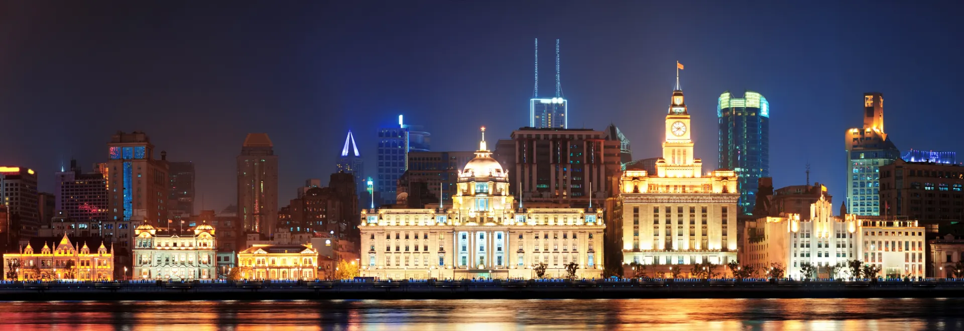 Night view of the Shanghai skyline and historic buildings along the Bund, representing the global stage of API SHANGHAI 2025 with Gaia in Love.