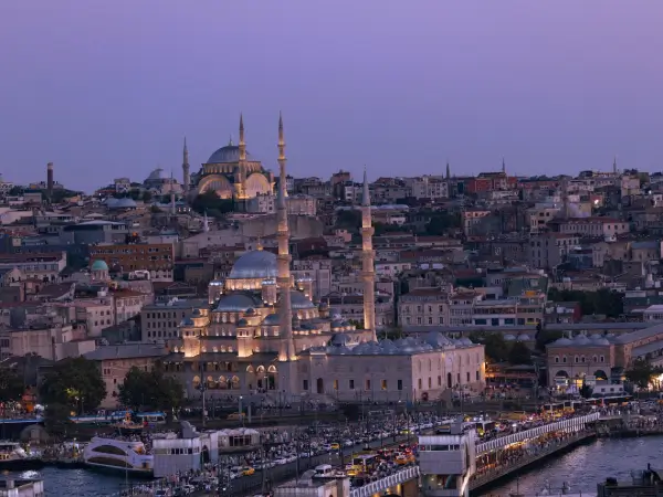 Akşam ışıkları altında İstanbul silüeti ve Galata Köprüsü manzarası.