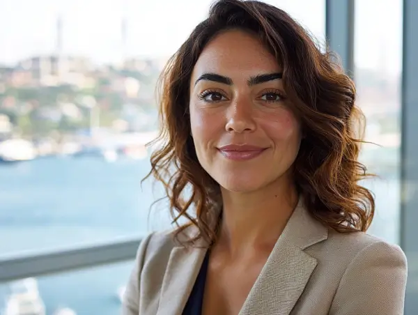 Gülümseyen iş kadını, Boğaz manzaralı modern bir ofiste kameraya bakıyor.