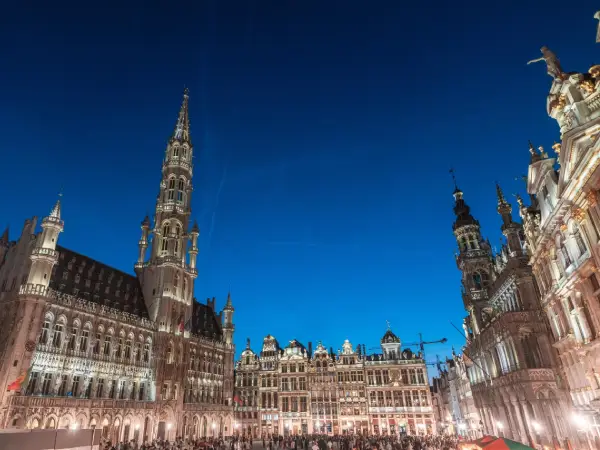 Grand-Place de Bruxelles en soirée, bâtiments historiques illuminés et foule au centre-ville de Belgique