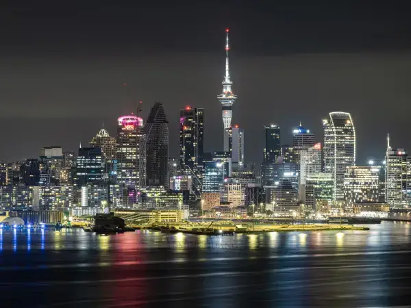 Auckland city skyline and Sky Tower reflected in the harbour at night – Gaia Sex Tech New Zealand