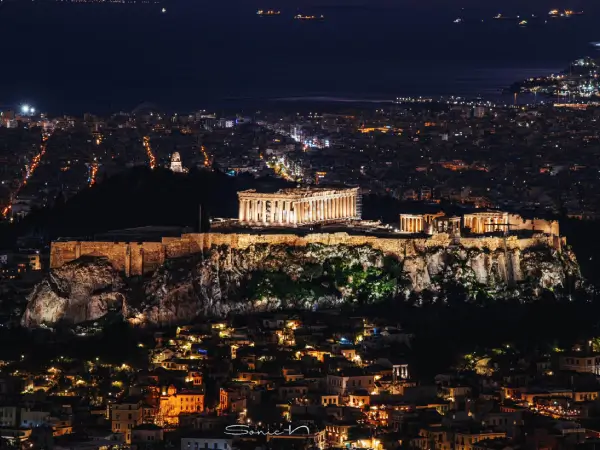 Η Ακρόπολη της Αθήνας φωτισμένη τη νύχτα, σύμβολο της ελληνικής κληρονομιάς και της καινοτομίας.