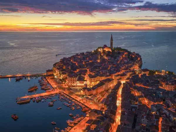 Zračni pogled na osvijetljeni stari grad Rovinja i marinu na Jadranskom moru u zalazak sunca.