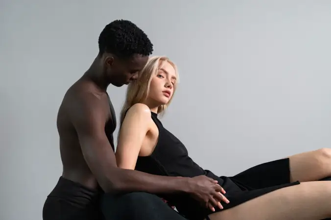 Couple embracing in minimalist black lingerie, concept image for couples remote control vibrators.