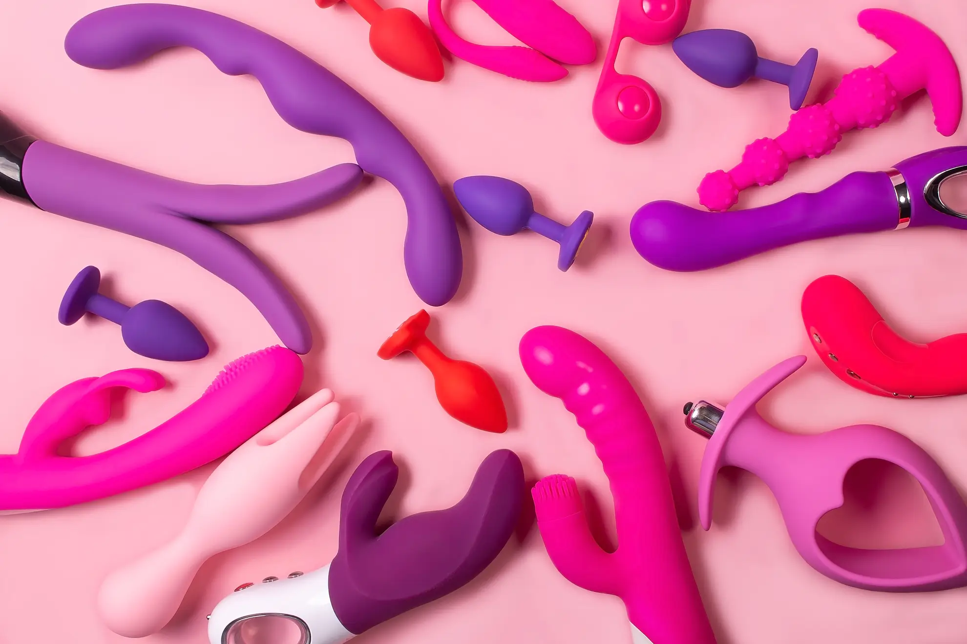 Surtido de juguetes sexuales de silicona en rosa y morado (vibradores, juguetes para parejas y plugs anales) que abarca colecciones para mujeres, hombres, parejas y lesbianas.