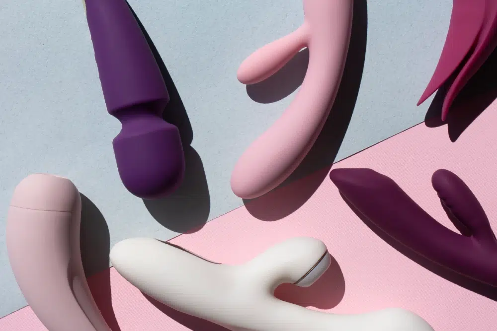 Assorted Gaia vibrators in soft colors on a pink and blue background